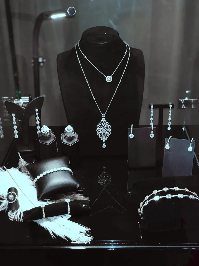 NADESA vitrine with a long necklace and rings on feathers